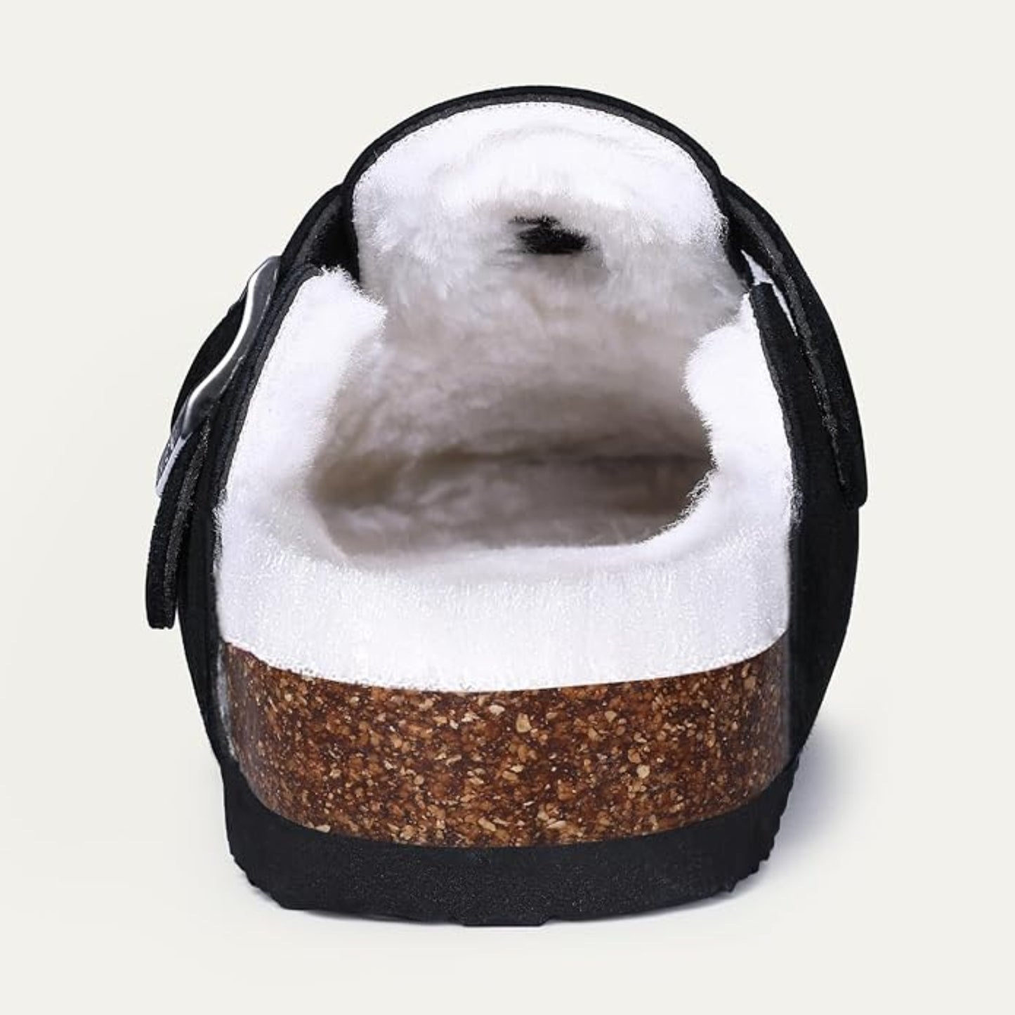 Cute seal plush toy inside a black and brown shoe on a light gray background